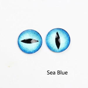 Macro detail of round sea blue cat eye glass cabochons with black pupils for DIY jewelry