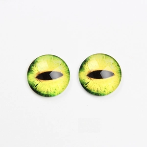 Detail of green-yellow glass cat eyes with vertical pupils for DIY jewelry making
