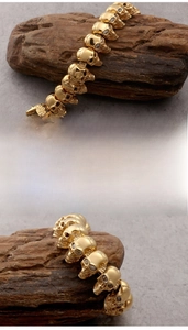 Detailed close-up of punk gold skull bracelet with polished finish and cubic zirconia eyes