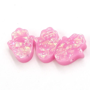 Three pink resin Fatima Hand pendants with glitter sequins on a white background