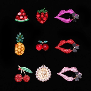 Detailed view of colorful rhinestone fruit and lip charms for DIY craft accessories