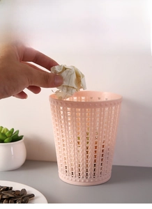 Detail of pink mini tabletop trash can with elegant hollow woven texture and dot border