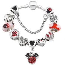 Detailed close-up of beaded snake chain bracelet with Mickey theme charms and red crystals