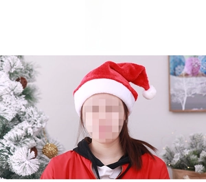 Gros plan d'un bonnet de Noël en peluche rouge avec bordure et pompon en fausse fourrure