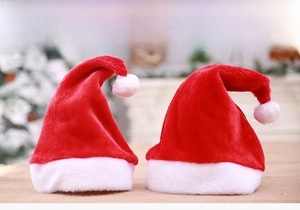 Détail de deux bonnets de Noël en peluche rouge et blanc avec pompons pour les fêtes
