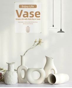 Close-up of five matte white ceramic vases in various minimalist shapes with dry flowers