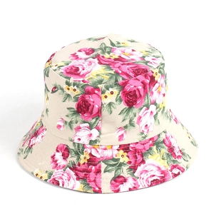 Dettaglio di un cappello da pescatore beige con stampe floreali di rose rosse e rosa