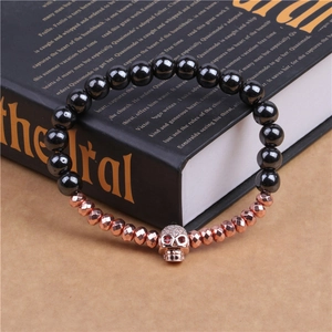 Gros plan détaillé d'un bracelet tête de mort avec perles noires sur un livre vintage