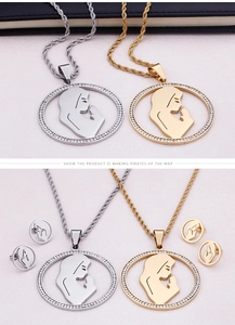 Detailed close-up of religious pendant earrings set with rhinestones in gold and silver