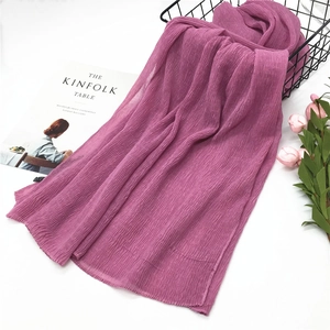 Close-up of magenta cotton linen scarf with crinkle texture in elegant lifestyle setting