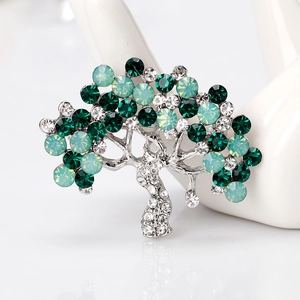 Elegant silver tree brooch featuring emerald green crystals and sparkling rhinestones