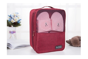 Detail of red travel shoe bag with mesh window holding pink slippers and a sturdy handle