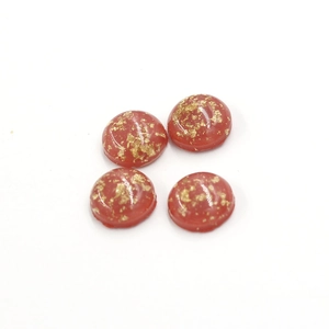 Macro detail of 12mm synthetic opal resin cabochons with gold foil flakes in pink