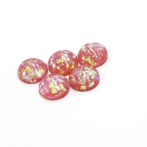 Macro detail of 12mm pink synthetic opal resin cabochons with iridescent foil flakes