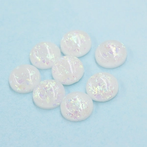 Macro shot of 12mm white oval synthetic opal resin stones with colorful iridescent foil effect