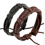 Detail of black and brown braided leather bracelets with adjustable cords on white background