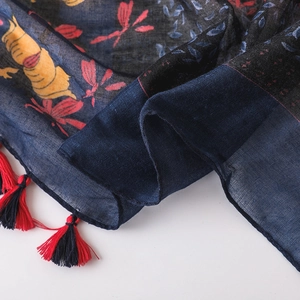 Detail of floral printed cotton linen scarf featuring colorful dragonfly patterns and tassels