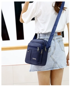 Detailed back view of navy blue oxford shoulder bag with multi-zipper layers and wide strap