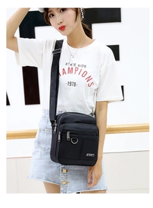 Detail of black waterproof oxford shoulder bag featuring multi-zipper compartments