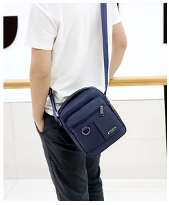 Detailed view of deep blue waterproof Oxford fabric crossbody bag with wide shoulder strap