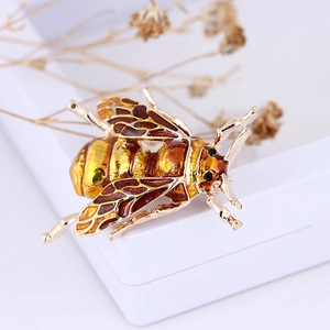 Detailed view of an alloy honeybee brooch with amber enamel and sparkling rhinestones