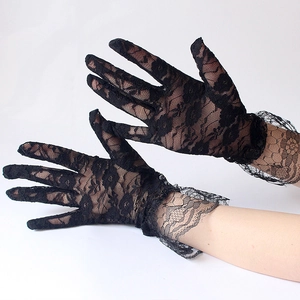 Detail of delicate floral lace pattern on black short bridal gloves for sun protection