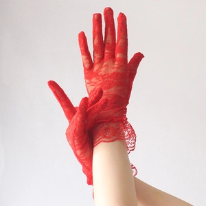 Detailed close-up of red lace floral gloves showing delicate embroidery and mesh texture