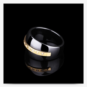 Close-up of 14mm two-tone black ceramic ring with gold inlay and pavé crystals