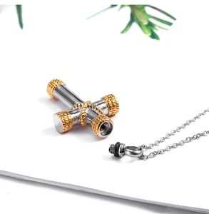Detail of silver and gold cross keepsake pendant with threaded screw cap and chain
