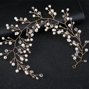 Détail de vigne de cheveux de mariée dorée avec perles blanches et cristaux
