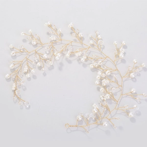 Détail d'une vigne de cheveux de mariée avec fil doré, perles blanches et perles cristal