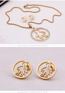 Detail of gold titanium steel jewelry set with hollow round boy pendant and studs
