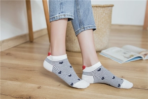 Detail of white striped low-cut socks with navy stripes and a red heart heel tab