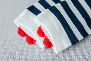 Close-up of blue-white striped cotton socks featuring red heart-shaped scalloped edges