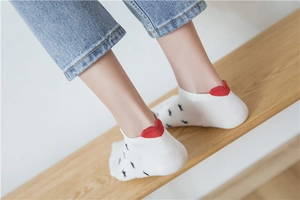 Detail of white cotton socks with black stars and a red heart-shaped heel cushion