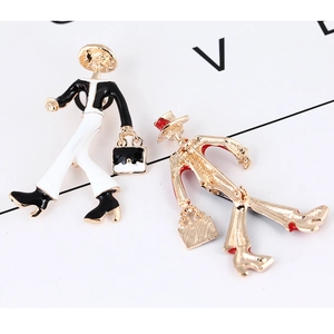 Detailed view of two modern lady brooches with enamel finish and gold plating