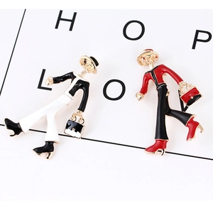 Detail view of stylish enamel girl brooches with hat and bag in red, black, and gold colors