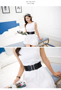 Detail of a black wide elastic waist belt with a silver multi-bar buckle on a dress