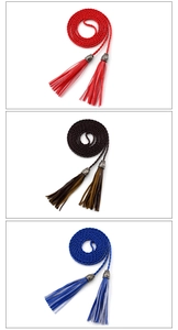 Detailed view of woven tassel waist belts in red, dark brown, and royal blue colors