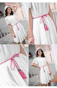 Detail shots of white chiffon dress paired with a pink braided tassel waist belt