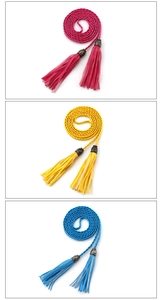 Detail of woven thin waist belts with tassels in rose red, yellow, and royal blue colors