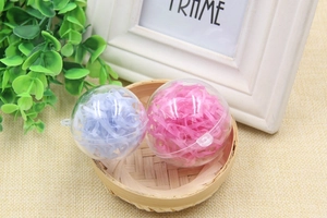 Close-up of clear decorative ball filled with pink and blue shredded raffia paper