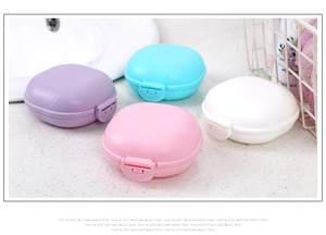 Set of four pastel waterproof travel soap boxes with locking lids on a bathroom sink