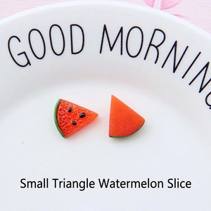 Close-up of small resin watermelon slices on a ceramic plate for DIY jewelry making