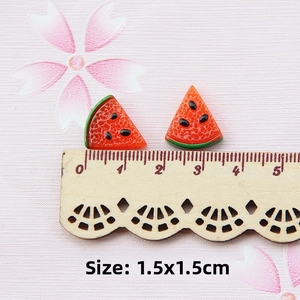 Macro shot of resin watermelon slice charm on a ruler showing 1.5x1.5cm size