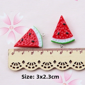 Macro detail of resin watermelon slice charms with silver loops for DIY jewelry