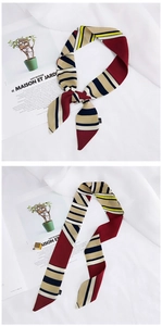 Detail of colorful striped silk scarf tied and flat on magazine background
