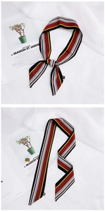 Detail of red and blue striped silk scarf on magazine, tied and laid flat