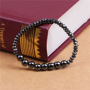 Detailed close-up of black faceted stone beads and smooth round beads on a snake chain