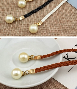 Detail of woven waist rope belts with pearl pendants in black, white and brown